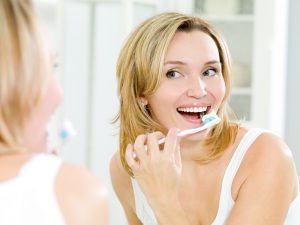 woman maintaining good oral hygeine at home.